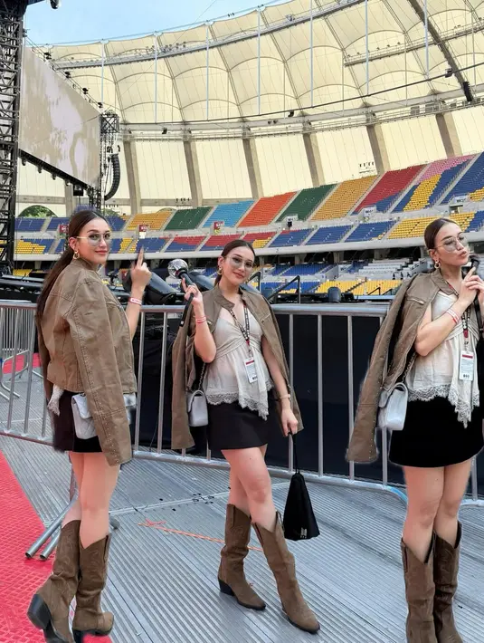 Ayu Ting-Ting mengenakan atasan bergaya baby doll dengan rok mini dan boots velvet cokelat. Outfit ini dilapisi dengan jaket cokelat [@ayutingting92]