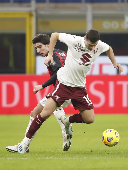 Gelandang AC Milan, Sandro Tonali berebut bola dengan gelandang Torino, Amer Gojak pada babak 16 besar Coppa Italia 2020/2021 di San Siro, Rabu (13/1/2021) dini hari WIB. Laga terkunci 0-0, AC Milan menang 5-4 atas Torino di babak adu penalti. (AP Photo/Antonio Calanni)