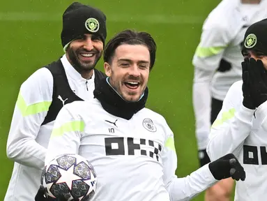 (kiri-kanan) Pemain Manchester City Riyad Mahrez, Jack Grealish, dan Ilkay Gundogan bercanda saat sesi latihan di tempat latihan Manchester City di Manchester, Inggris, 13 Maret 2023. Manchester City akan menghadapi RB Leipzig pada pertandingan sepak bola leg kedua babak 16 besar Liga Champions. (Paul ELLIS/AFP)