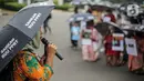 Pekerja rumah tangga (PRT) berorasi saat menggelar aksi di depan Taman Aspirasi Monas, Jakarta, Rabu (21/12/2022). Aksi tersebut dilakukan untuk memperingati Hari Ibu serta meminta pemerintah untuk mengesahkan Rancangan Undang-Undang Perlindungan Pekerja Rumah Tangga (RUU PPRT). (Liputan6.com/Faizal Fanani)