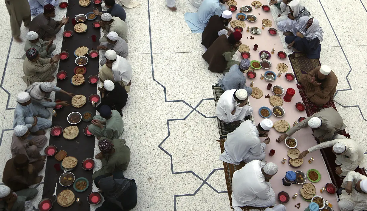 Sejumlah umat Muslim berbuka puasa, selama bulan suci puasa Ramadhan, di sebuah masjid di Peshawar, Pakistan, Rabu (14/4/2021). Bulan Ramadhan ditandai dengan berpuasa setiap hari dari fajar hingga matahari terbenam. (AP Photo/Muhammad Sajjad)