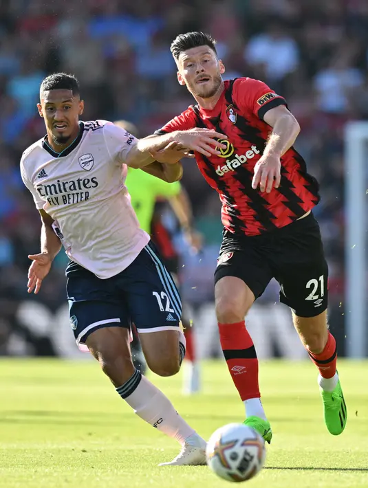 Pemain Arsenal William Saliba (kiri) berebut bola dengan pemain Bournemouth Kieffer Moore pada pertandingan sepak bola Liga Premier Inggris di Stadion Vitality, Bournemouth, Inggris, 20 Agustus 2022. Arsenal menang 3-0. (Glyn KIRK/AFP)