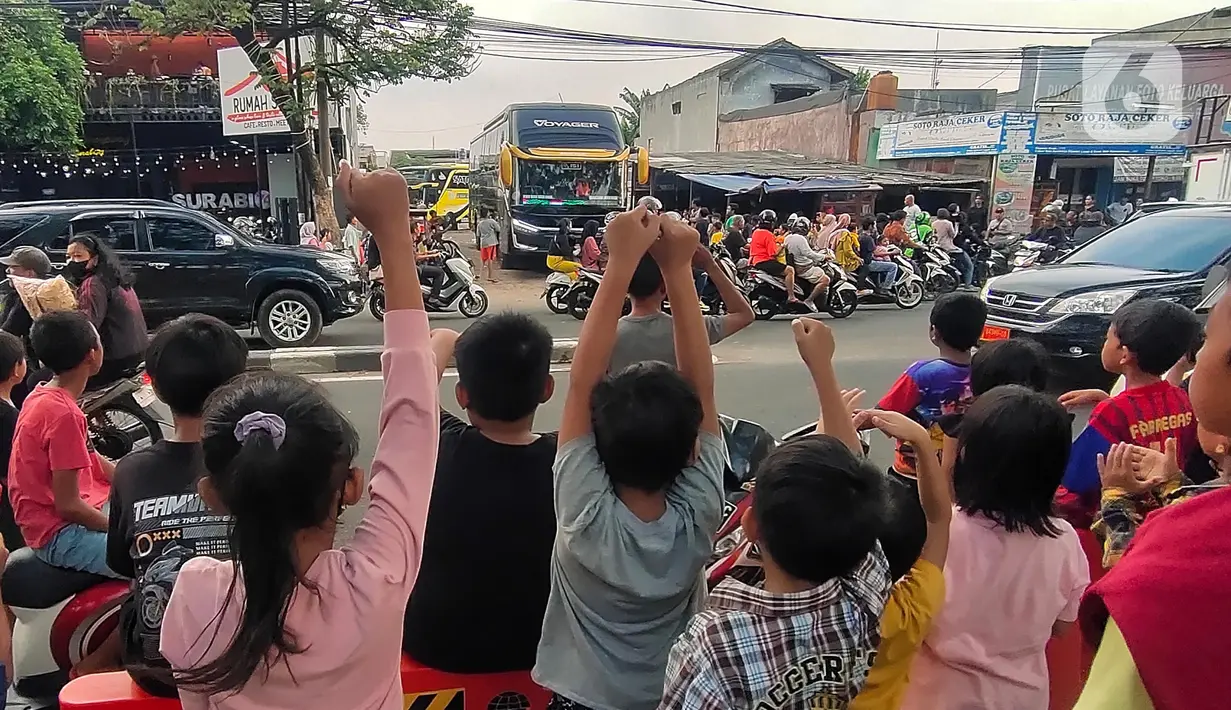 Sejumlah anak berjoget sambil merekam fenomena klakson bus telolet yang kembali marak di Jalan Raya Ciledug, Tangerang, Minggu (18/6/2023). (Liputan6.com/Angga Yuniar)