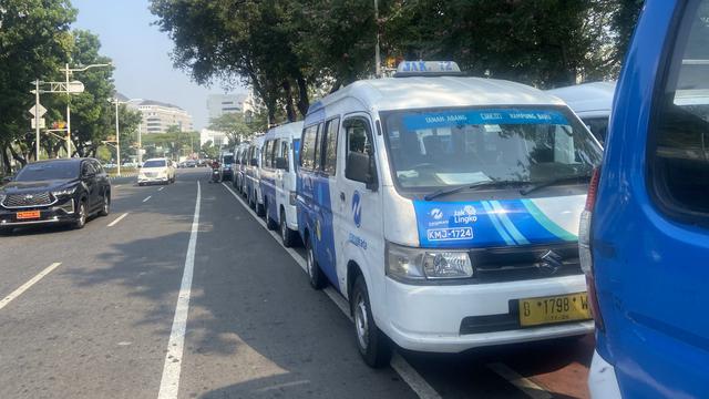Ratusan kendaraan JakLingko terparkir di kawasan Balai Kota Jakarta. Rupanya, para sopir JakLingko menggelar demo protes menyuarakan ketidakadilan manajemen TransJakarta.
