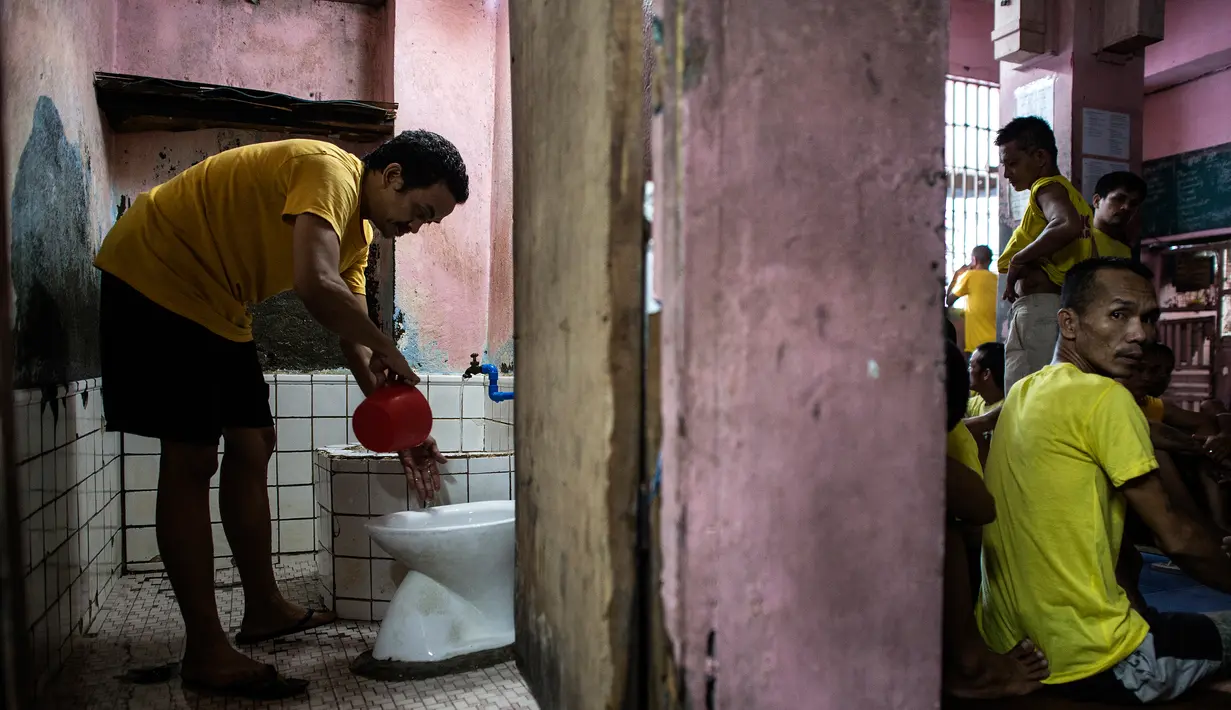 Seorang narapidana menggunakan toilet di dalam penjara Quezon City di Manila, Filipina, 29 Juli 2016. Kondisi sanitasi penjara Quenzon City sangat buruk, hanya terdapat satu toilet yang digunakan hingga 130 narapidana. (Noel Celis/AFP)