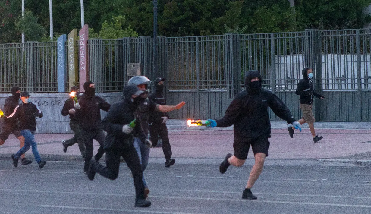 Pengunjuk rasa bersiap melemparkan bom molotov ke arah polisi antihuru-hara saat unjuk rasa terkait kematian warga Afrika-Amerika yang bernama George Floyd di Athena, 3 Juni 2020. Ribuan orang ambil bagian dalam unjuk rasa di ibu kota Yunani pada Rabu (3/6) atas kematian Floyd. (Xinhua/Marios Lolos)