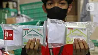Pekerja menunjukkan paket obat COVID-19 di salah satu gerai ekspedisi SiCepat di Jalan K.S Tubun, Petamburan, Jakarta, Sabtu (17/7/2021). Pemerintah resmi membagikan 300 ribu paket obat gratis untuk pasien COVID-19 yang menjalani isolasi mandiri di Pulau Jawa dan Bali. (Liputan6.com/Herman Zakharia)