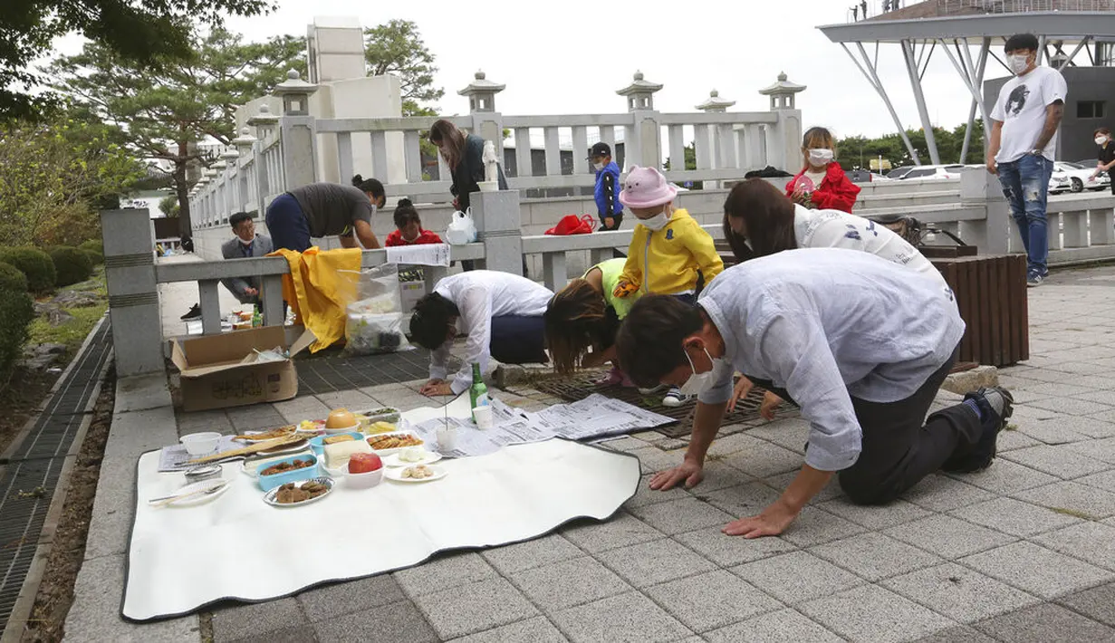 Pembelot Korea Utara Yoo Soon-nyeo (kelima dari kanan) dan anggota keluarganya membungkuk untuk menghormati leluhur mereka di Korea Utara saat merayakan Chuseok dekat perbatasan dengan Korea Utara di Paviliun Imjingak, Paju, Selatan Korea, Kamis (1/10/2020). (AP Photo/Ahn Young-joon)