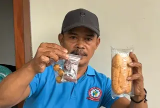 Warga menunjukkan menu MBG