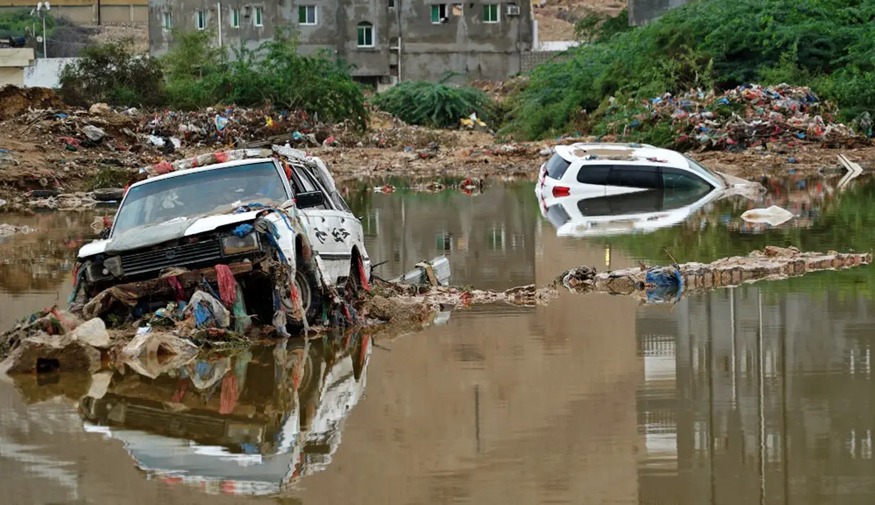 Mobil-mobil terjebak air berlumpur menyusul banjir yang disebabkan oleh Topan Shaheen di Mukalla, Provinsi Hadramaut, Yaman, Kamis (7/10/2021). Topan Shaheen yang melanda negara tetangga, Oman, mempengaruhi wilayah tersebut. (AFP)
