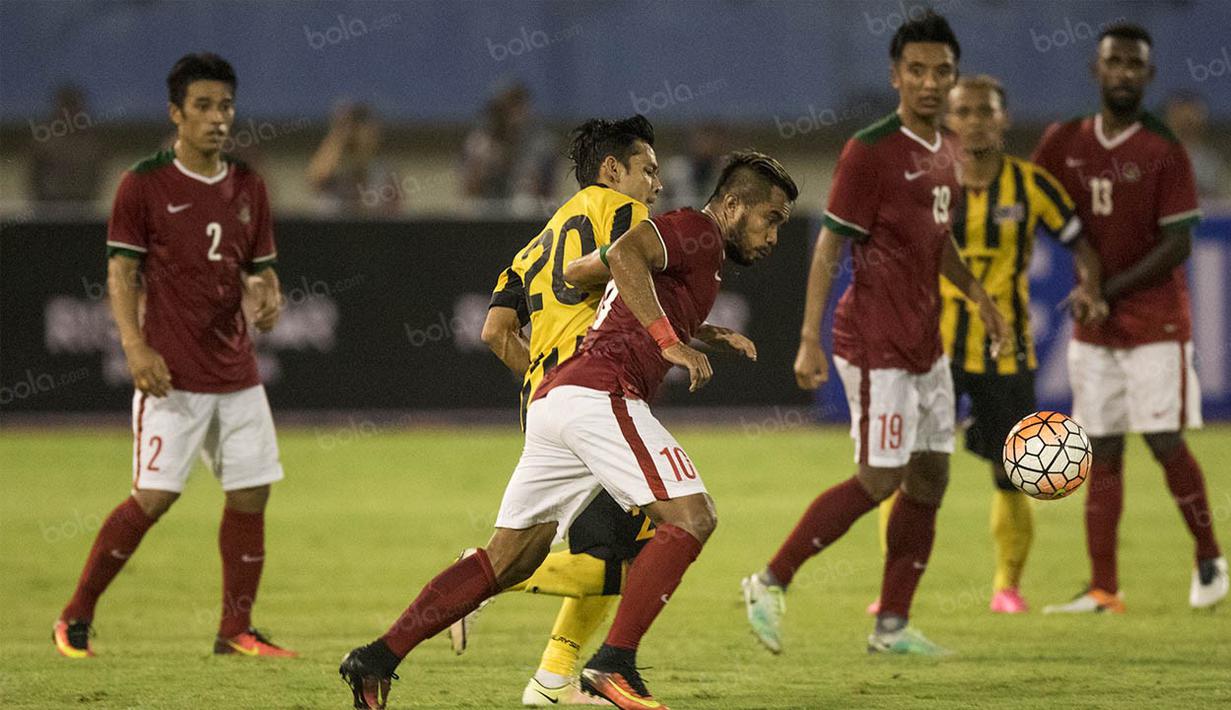 Gelandang Indonesia, Zulham Zamrun, melewati hadangan gelandang Malaysia, Mohd Azrif Nasrulhaq. Selaku tuan rumah tim Garuda langsung menekan pertahanan negeri Jiran sejak menit pertama. (Bola.com/Vitalis Yogi Trisna)