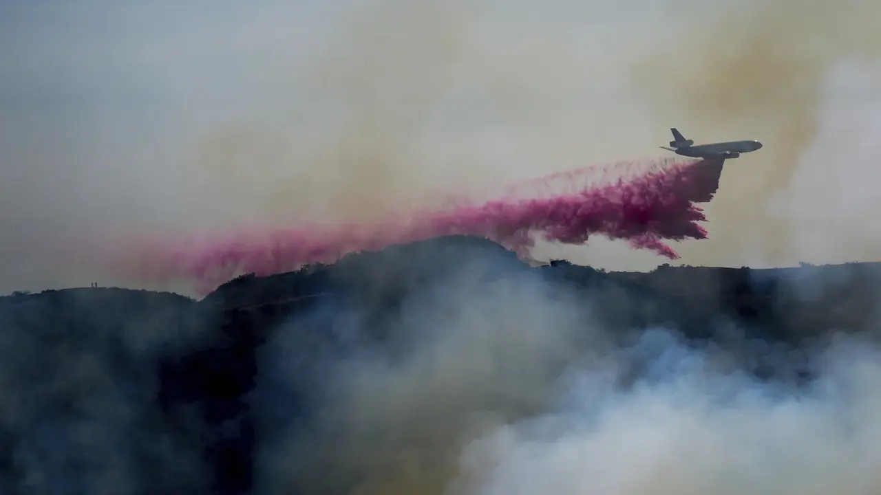 Zat seperti bubuk berwarna pink atau merah muda yang menutupi kendaraan dan jalan masuk saat terjadi kebakaran hutan Los Angeles. (AP)