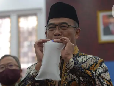 Menko PMK Muhadjir Effendy memperagakan alat GeNose C19 buatan Universitas Gadjah Mada (UGM) di Kementerian PMK, Jakarta, Kamis (7/1/2021). Alat itu diserahkan oleh Menteri Riset dan Teknologi Bambang Brodjonegoro, Kamis (7/1/2021). (merdeka.com/Imam Buhori)