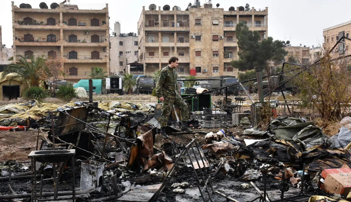 Tentara Rusia berdiri di puing-puing dari rumah sakit lapangan militer Rusia yang diserang pemberontak oposisi Suriah di Aleppo, Senin (5/12). Serangan ini menewaskan seorang petugas medis militer perempuan dan melukai dua lainnya. (GEORGE OURFALIAN/AFP)