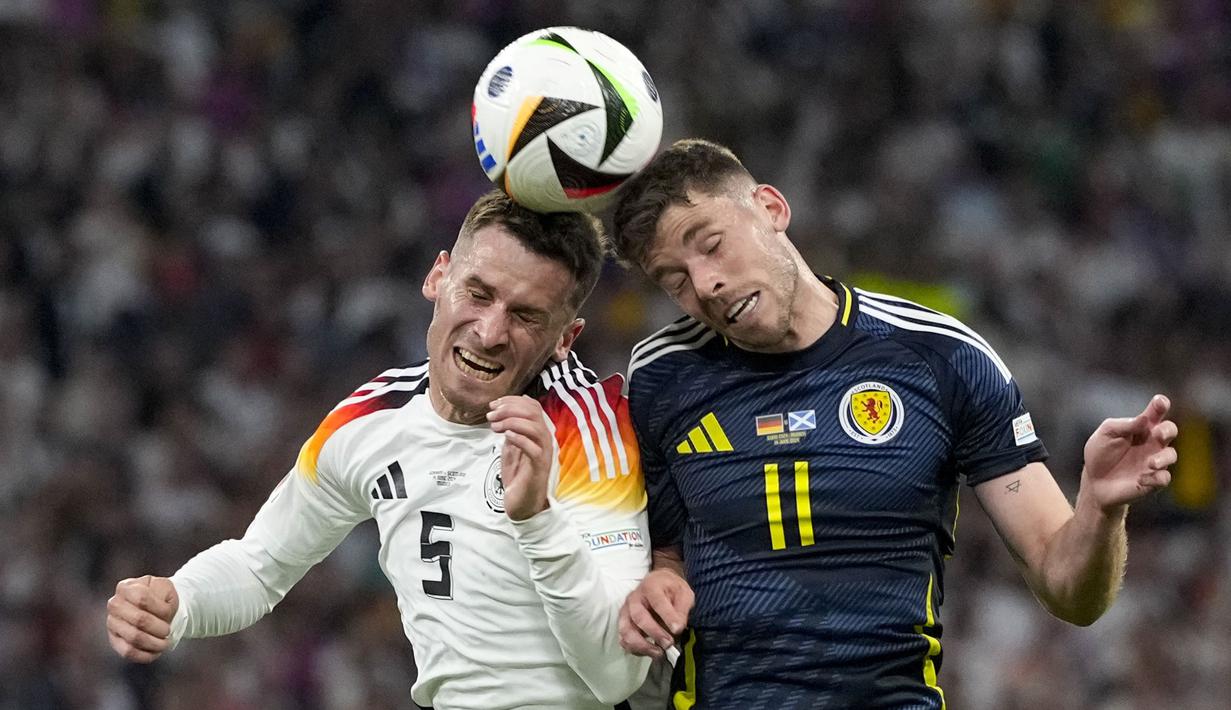 Pemain Jerman, Pascal Gross (kiri) berduel udara dengan pemain Skotlandia, Ryan Christie pada laga pembuka Grup A Euro 2024 di Allianz Arena, Munchen, Jerman, Sabtu (15/06/2024) WIB. (AP Photo/Antonio Calanni)