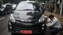 Petugas Dinas Perhubungan DKI Jakarta terlihat sedang mengempiskan mobil yang terparkir di depan Gedung DPRD, Jakarta, Senin (12/1/2015).  (Liputan6.com/Johan Tallo)
