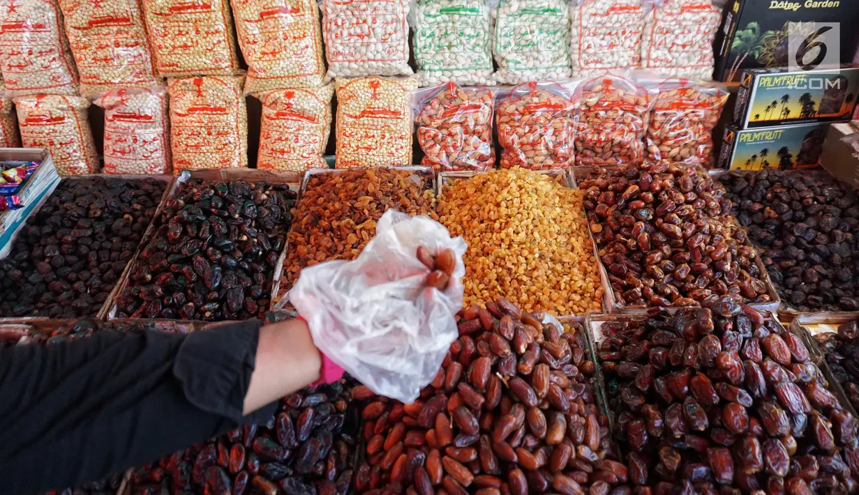 Pedagang kurma menunjukkan barang dagangannya di Pasar Tanah Abang, Jakarta, Kamis (2/5). Menjelang bulan Ramadan, permintaan buah kurma meningkat dua kali lipat dibanding hari biasa. (Liputan6.com/JohanTallo)
