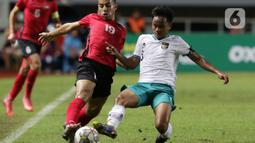 Pemain Timnas U-17 Indonesia, M Hanif Ramadhan (kanan) berebut bola dengan Mahmoud Radi (Palestina U-17) pada Kualifikasi Grup B Piala Asia U-17 2023 di Stadion Pakansari, Kab. Bogor, Jawa Barat, Jumat (7/10/2022). Kemenangan atas Palestina memperbesar peluang timnas U-17 Indonesia lolos ke Piala Asia U-17 2023. (Liputan6.com/Helmi Fithriansyah)