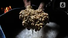 Perajin menunjukkan kedelai impor untuk membuat tempe di industri rumahan kawasan Sunter Jaya, Tanjung Priok, Jakarta, Kamis (13/1/2022). Sistem Pemantauan Pasar dan Kebutuhan Pokok Kementerian Perdagangan mencatat harga kedelai impor mengalami kenaikan 0,8 persen. (merdeka.com/Iqbal S. Nugroho)