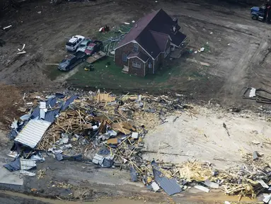 Rumah dan mobil yang rusak terlihat di Waverly, Tennessee, Rabu (25/8/2021). Hujan deras selama akhir pekan menyebabkan banjir di Tennessee Tengah dan telah mengakibatkan puluhan orang tewas karena rumah dan jalan pedesaan hanyut. (AP Photo/Mark Humphrey)