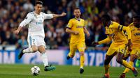 Pemain Real Madrid, Cristiano Ronaldo menendang bola dengan dibayangi pemain Juventus pada leg kedua babak perempat final Liga Champions di Santiago Bernabeu, Rabu (11/4). Real Madrid melaju ke semifinal meski kalah 1-3 dari Juventus. (AP/Paul White)
