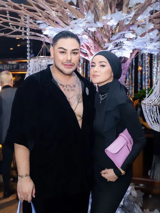 Olla Ramlan juga datang pakai turtleneck dress hitam. Hand bag warna pink pun jadi statement. [IG:nathalieholscher].