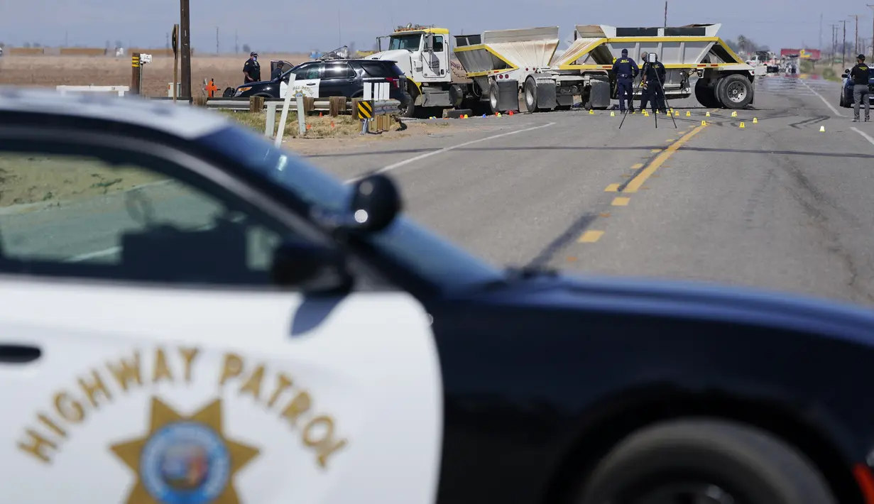 Petugas mengecek lokasi kecelakaan mematikan truk yang menabrak mobil SUV di Holtville, California (2/3/2021). Insiden itu terjadi di jalan bebas hambatan di daerah Holtville, California pada Selasa (2/3). (AP Photo/Gregory Bull)