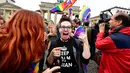 Seorang wanita merayakan keputusan legalisasi undang-undang pernikahan sesama jenis di depan Gerbang Brandenburg di Berlin (30/6). Dengan keputusan itu, maka UU pernikahan sejenis ini akan berlaku pada akhir tahun ini. (AFP Photo/Tobias Schwarz)