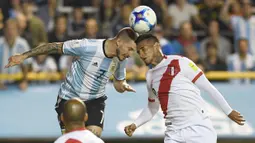 Duel pemain Argentina, Dario Benedetto dan pemain Peru, Miguel Trauco (kanan) pada laga Kualifikasi Piala Dunia 2018 di Buenos Aires, (5/10/2017). Argentina bermain imbang 0-0 lawan Peru. (AFP/Eitan Abramovich)