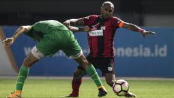 Penyerang Persipura, Boaz Solossa, berebut bola dengan bek Bhayangkara FC, Otavio Dutra, pada laga Liga 1 Indonesia di Stadion Patriot, Bekasi, Sabtu (9/9/2017). Bhayangkara FC menang 2-1 atas Persipura. (Bola.com/Vitalis Yogi Trisna)