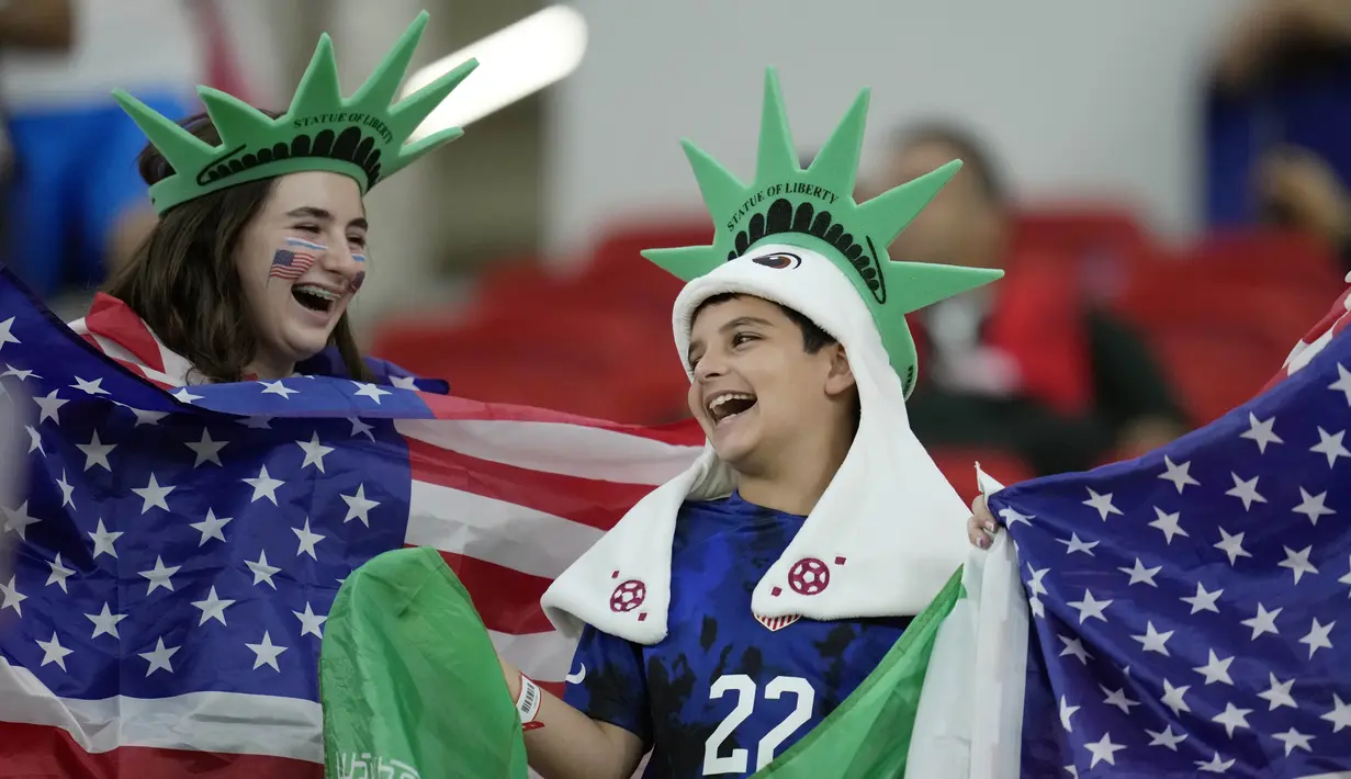 Penggemar sepak bola Amerika Serikat membawa bendera negaranya sebelum pertandingan grup B Piala Dunia antara Iran dan Amerika Serikat di Stadion Al Thumama di Doha, Qatar, Selasa, 29 November 2022. (AP Photo/Ashley Landis)