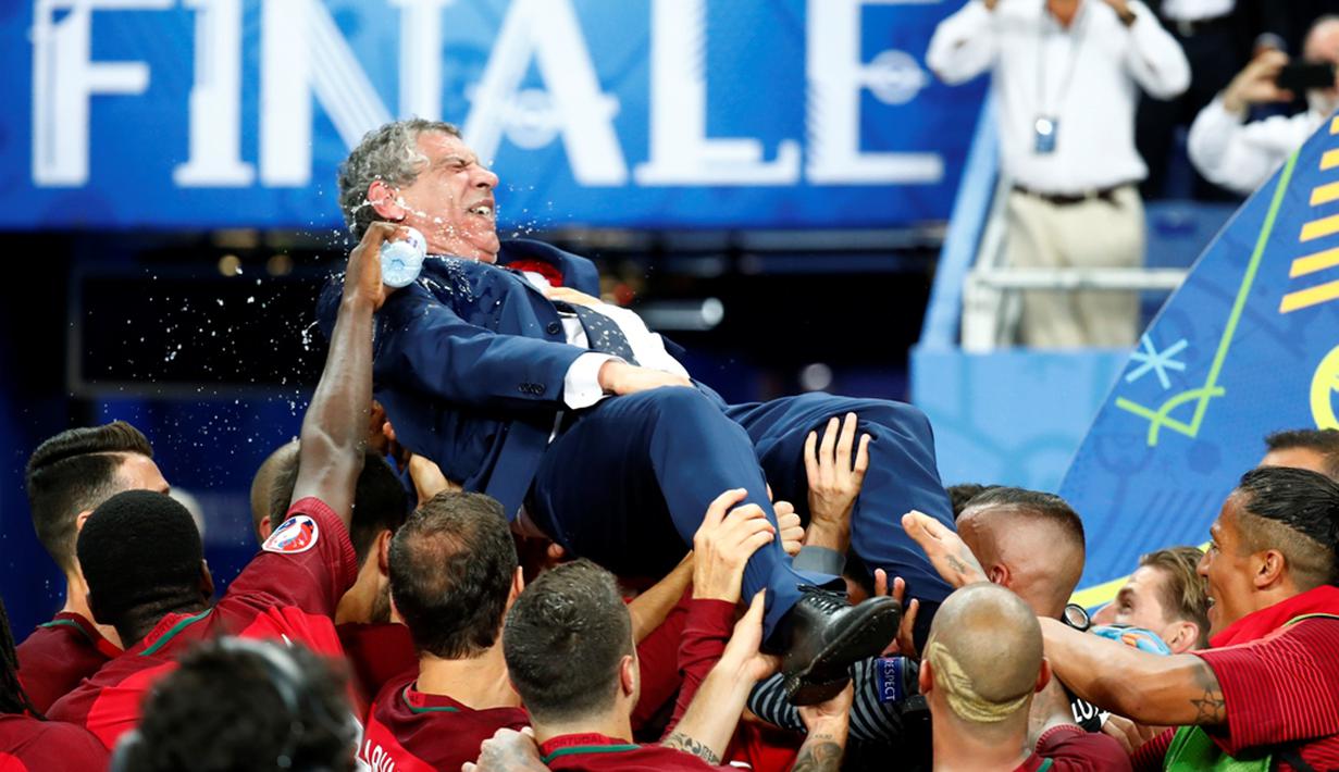 Pemain Portugal mengangkat sang pelatih, Fernando Santos, setelah menjadi juara Piala Eropa 2016 di Stade de France, Saint-Denis, Senin (11/7/2016) dini hari WIB. (Reuters/Kai Pfaffenbach)