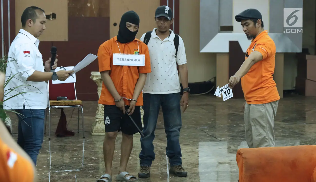 Tersangka HS pelaku kasus pembunuhan satu keluarga di Bekasi (kedua kiri) melakukan pra-rekonstruksi di Polda Metro Jaya, Jakarta, Senin (19/11). 35 adegan diperagakan dari 57 yang akan diperagakan saat rekonstruksi. (Liputan6.com/Helmi Fithriansyah)