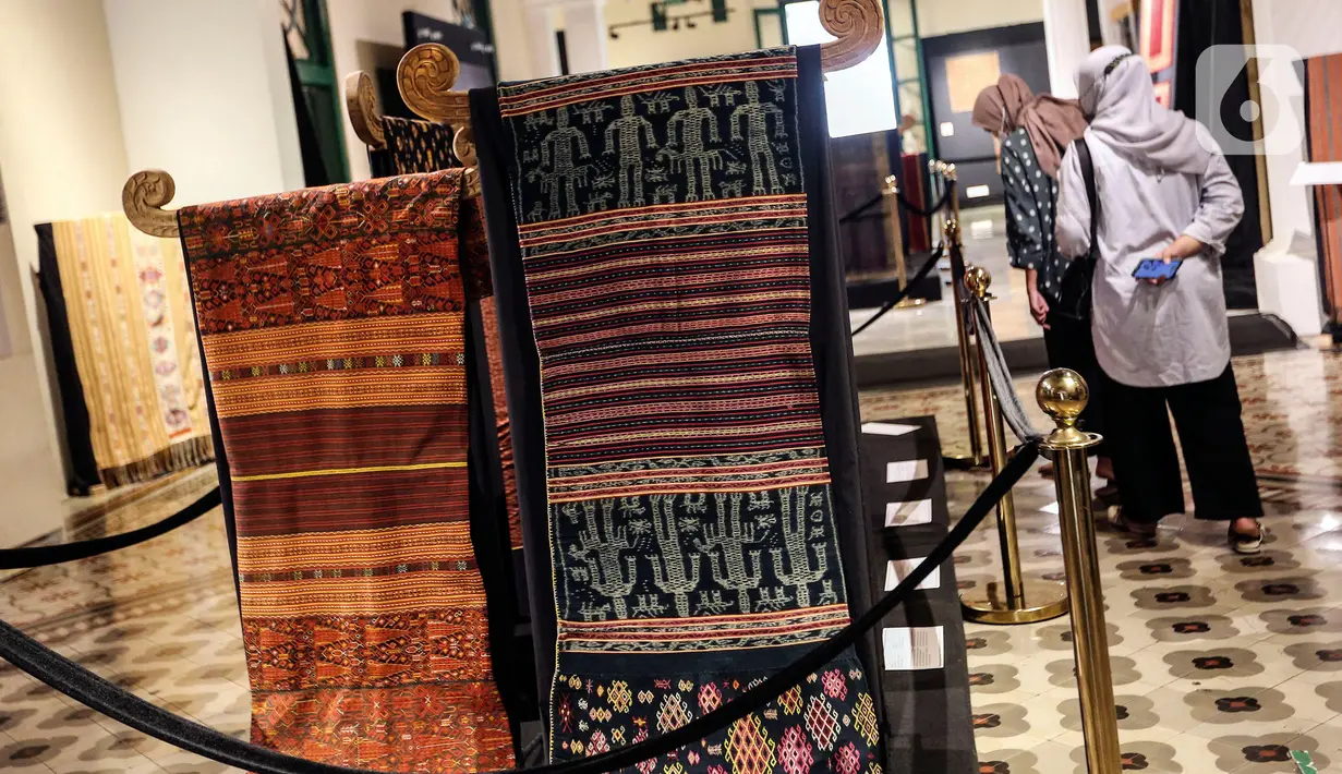 Pengunjung melihat kain tenun di pameran tenun bertajuk "Nuansa Kemilau Wastra Tenun Indonesia" di Museum Tekstil, Jakarta, Rabu (20/7/2022). Pameran dalam rangka memperingati HUT ke - 77 RI ini berlangsung hingga 31 agustus 2022 mendatang dan menampilkan kerajinan tenun dari Sumatera, Sulawesi, dan Timor. (Liputan6.com/Johan Tallo)