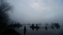 Para nelayan menarik jala saat tradisi panen ikan mas secara tradisional di dekat desa Mazelov, Republik Ceko, 15 November 2018. Tradisi panen ikan mas ini biasa dilakukan tahunan menjelang musim Natal. (AP/Petr David Josek)