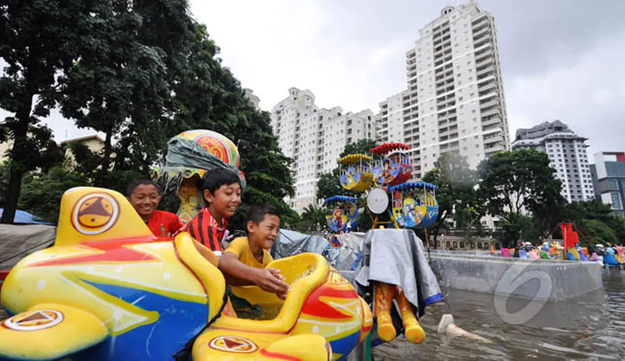Tingginya curah hujan di wilayah Jakarta mengakibatkan sejumlah daerah masih terendam banjir, Jakarta, Selasa (10/2). Tampak sejumlah anak bermain di lahan bermain Kemayoran yang terendam banjir. (Liputan6.com/Faizal Fanani)