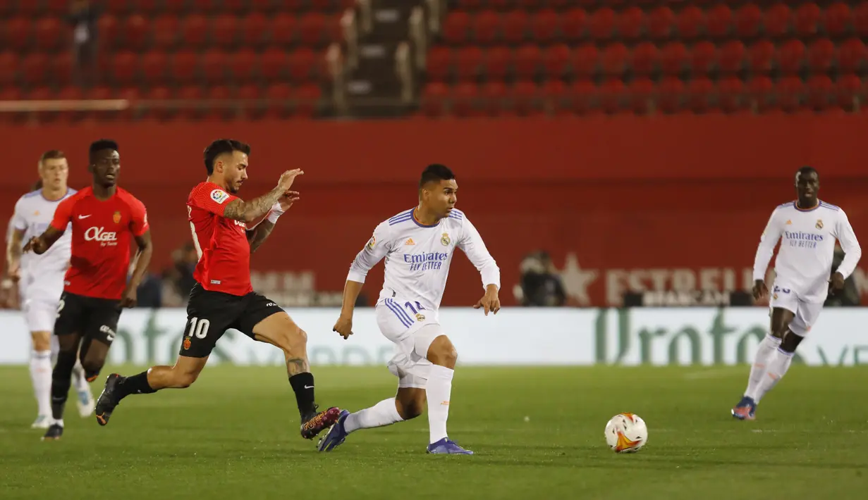 Gelandang Real Madrid, Casemiro membawa bola dari kejaran pemain Mallorca, Antonio Sanchez pada pertandingan lanjutan La Liga Spanyol di Palma de Mallorca, Spanyol, Selasa (15/3/2022). Madrid menang telak atas Mallorca 3-0. (AP Photo/Francisco Ubilla)