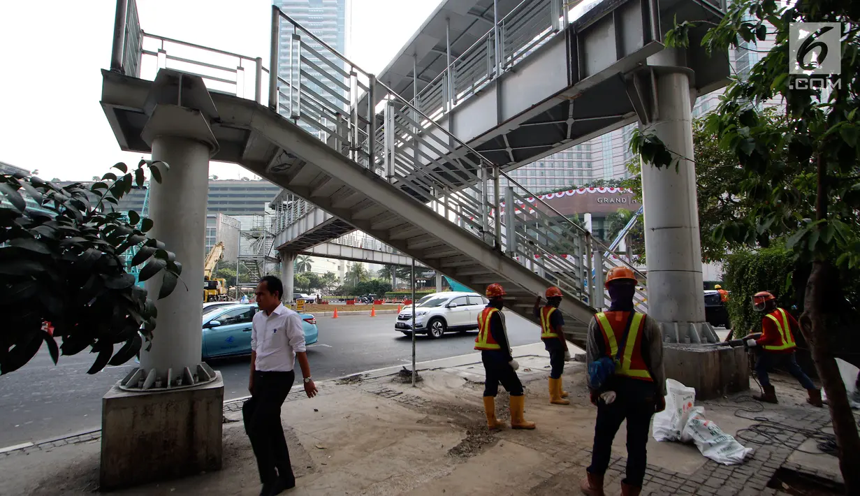 Pekerja melakukan Pembongkaran Jembatan Penyebrangan Orang (JPO) di Kawasan Bundaran HI, Jakarta, Senin (30/7). JPO yang sempat menimbulkan kontreversi itu dirobohkan karena alasan keindahan dan tak ramah penyandang disabilitas. (Liputan6.com/Johan Tallo)