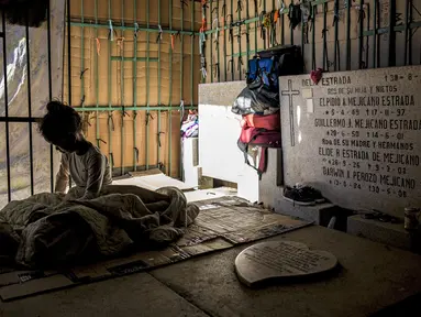 Seorang gadis beristirahat di tempat perlindungan darurat di Pemakaman Umum Selatan di Caracas, pada 10 Februari 2021. Makam yang dirusak telah menjadi rumah bagi banyak tunawisma di Venezuela. (Pedro Rances Mattey / AFP)