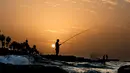 Sejumlah pria memancing iklan selama  matahari terbenam di atas garis pantai Laut Tengah, di Beirut, Lebanon (24/10). (AP Photo / Hassan Ammar)