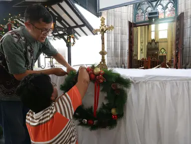 Umat kristen dan pengurus menata dekorasi di Gereja Katedral, Jakarta, Sabtu (23/12). Jelang perayaan natal Gereja Katedral mulai bebenah dan dipercantik untuk keperluan ibadah natal. (Liputan6.com/Angga Yuniar)