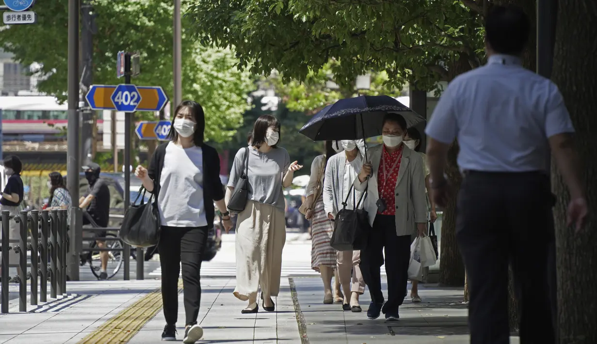 Orang-orang yang memakai masker melintasi persimpangan di Tokyo Kamis (5/8/2021). Tokyo pada hari Kamis melaporkan 5.042 kasus virus corona baru, rekor tertinggi harian terbaru sejak pandemi Covid-19 dimulai, di saat ibu kota Jepang menjadi tuan rumah Olimpiade. (AP Photo/Kantaro Komiya)