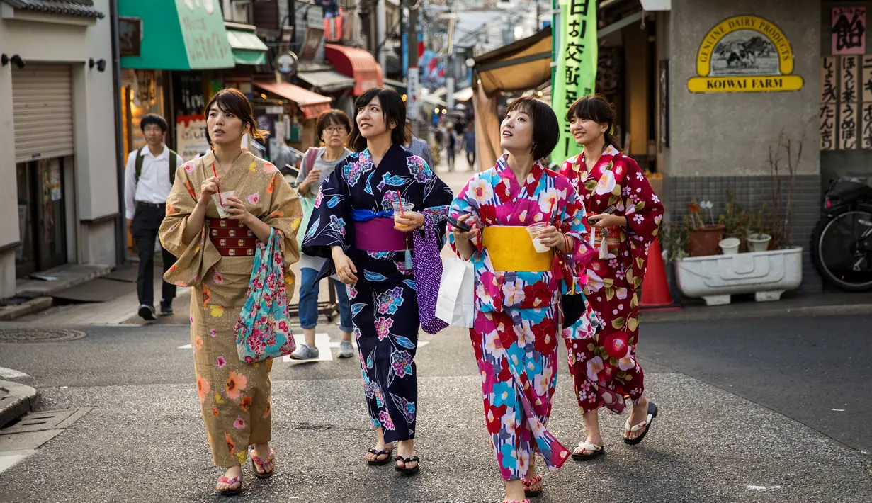 Sejumlah wanita memakai pakaian tradisional berjalan di sepanjang jalan perbelanjaan Yanaka Ginza di pusat Tokyo (30/9/2019). Bagian kota yang sudah tua ini terhindar dari pengeboman Sekutu selama Perang Dunia II dan selamat dari Gempa Besar Kanto dan Kebakaran tahun 1923. (AFP Photo/Odd Andersen)