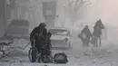 Seorang pria di kursi roda melarikan diri dengan sejumlah warga yang lain dari wilayah yang dikuasai pemberontak, Aleppo, Suriah (9/12). (REUTERS / Abdalrhman Ismail)