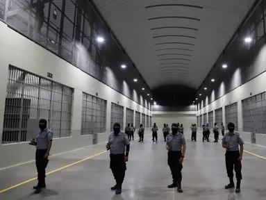 Penjaga sipil dari Direktorat Jenderal Penjara berdiri di luar sel tahanan saat tur media di Pusat Pengurungan Terorisme, Tecoluca, El Salvador, 2 Februari 2023. Menurut pemerintah, penjara besar yang masih dalam pembangunan tersebut memiliki kapasitas maksimum 40.000 narapidana dan dimaksudkan untuk memenjarakan anggota geng. (AP Photo/Salvador Melendez)