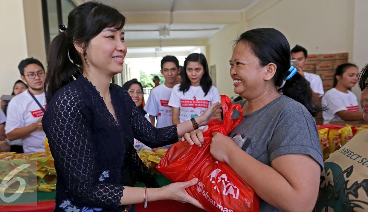 Istri Gubernur DKI Jakarta Basuki Tjahaja Purnama, Veronica Tan secara simbolis memberikan minyak goreng murah yang didistribusikan oleh Sinar Mas pada acara Bazaar Rakyat di Rusun Marunda, Jakarta Utara, Kamis (30/6). (Liputan6.com/Angga Yuniar)
