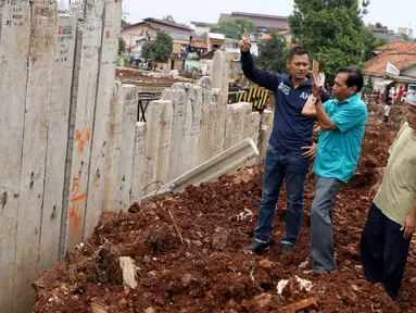 Bakal Cagub DKI, Agus Harimurti Yudhoyono mendengarkan penjelasan warga saat menyusuri pinggiran Sungai Ciliwung yang merupakan lokasi proyek normalisasi, di kawasan Bukit Duri, Jakarta, Kamis (20/10). (Liputan6.com/Gempur M Surya)