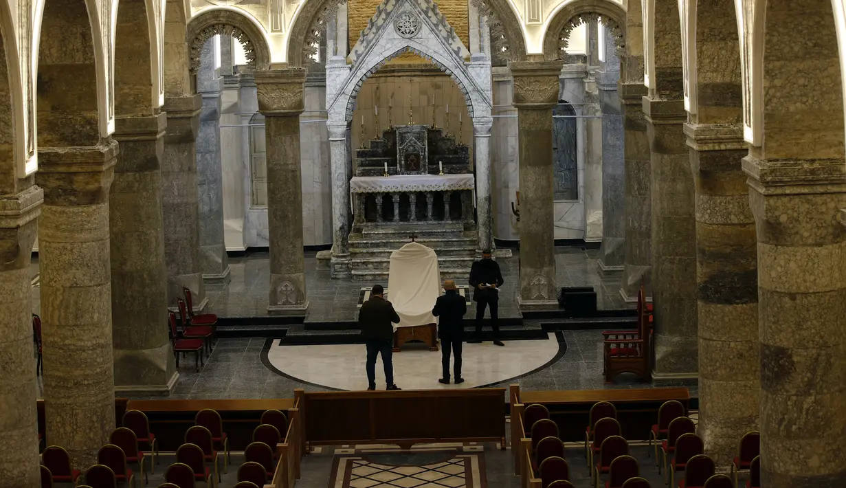 Umat Kristen Irak mempersiapkan Church of the Immaculate Conception di Qaraqos, Kamis, (4/3/2021). Pemimpin Tertinggi Umat Katolik Paus Fransiskus akan mengunjungi gereja tersebut selama perjalanan bersejarahnya ke Irak pada pekan ini. (AP Photo/Hadi Mizban)