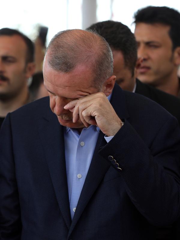 Presiden Turki Recep Tayyip Erdogan mengusap matanya saat menunaikan salat gaib untuk mantan Presiden Mesir Mohammed Morsi di Masjid Fatih, Istanbul, Selasa (18/6/2019). Erdogan diketahui memiliki kedekatan dengan Mohammed Morsi. (AP Photo/Emrah Gurel)
