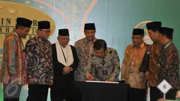 Wapres Jusuf Kalla disaksikan Ketua PBNU Said Aqil Siroj (ketiga kanan) saat menandatangani kartu NU Care pada acara peluncuran di Jakarta, Kamis (25/2). NU Care memberikan kemudahaan pada masyarakat untuk berzakat dengan tertib. (Liputan6.com/JohanTallo)